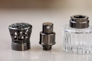 Perfume spray nozzle cap comparison with decorative metal cap and pump assembly on a glass fragrance bottle
